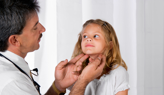 Doctor checking child's lymph nodes