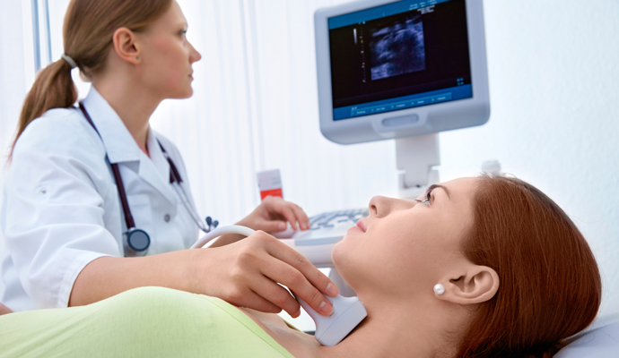 Woman undergoing ultrasound of thyroid