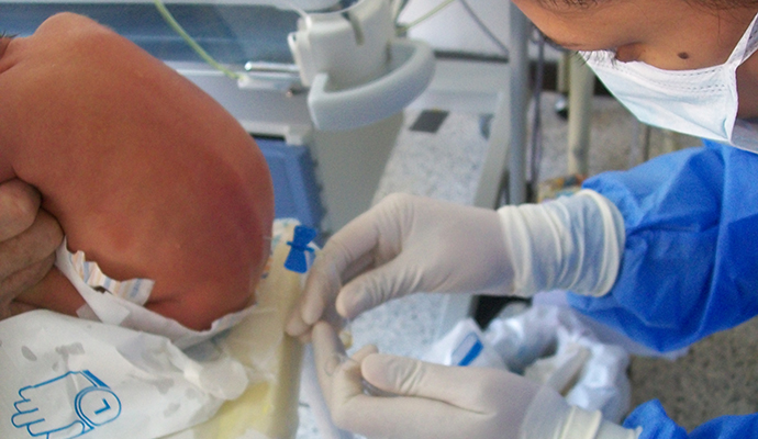 woman giving a lumbar puncture to a newborn