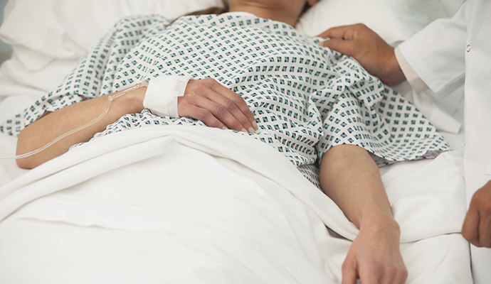 woman lying in a hospital bed with IV