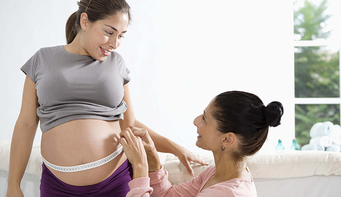 pregnant woman's belly being measured