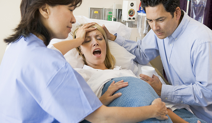 woman in labour with doctor and husband