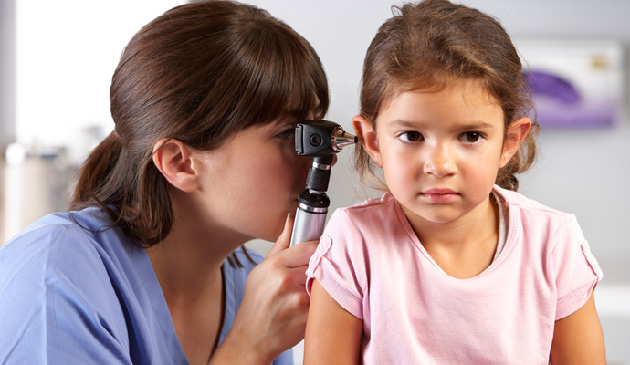 Nurse examining a young girl's ear
